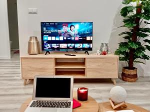 a living room with a laptop and a flat screen tv at BOUTIQUE LUXURY City Center in Alicante