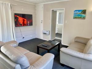 a living room with two couches and a table at Sunseeker in Ohope Beach