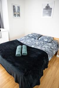 a bedroom with a bed with blue slippers on it at Flat at border suisse in Saint-Louis