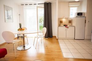 a kitchen and dining room with a table and chairs at Flat at border suisse in Saint-Louis