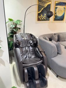 a black chair in a living room next to a couch at Goldcrest Signature Stays - DHA Lahore Phase 4 in Lahore +34 photos