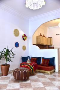 a living room with a red couch and a potted plant at Dar Marshan Family Luxury - Heart of Tangier in Tangier +24 photos