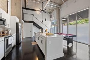 a large kitchen with white cabinets and a staircase at Luxury Loft-Coastal Vibe in Dallas +11 photos