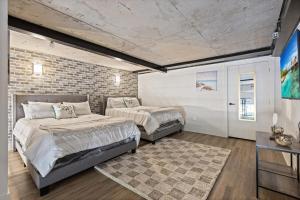 a bedroom with two beds and a brick wall at Luxury Loft-Coastal Vibe in Dallas