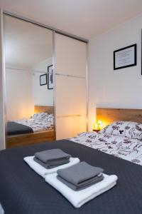 una camera da letto con un letto con due asciugamani sopra di Apartman oak Nikola's lamp a Gospić