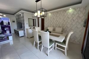 a dining room with a white table and chairs at Sunshine Palmares de Caleta in La Romana