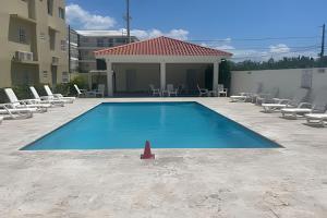 a swimming pool with chairs and a red cone next to it at Sunshine Palmares de Caleta in La Romana