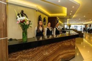 three women standing at a counter in a hotel lobby at Hotel Dali Plaza Ejecutivo in Guadalajara