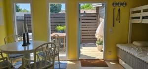 a dining room with a table and a balcony at Ocean Breeze next to the Beach in Beddinge Strand +4 photos