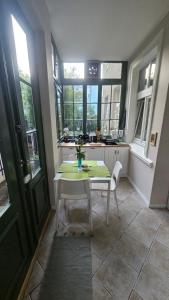 a kitchen with a table and chairs and windows at Baltic Swans - Studio in Sopot +7 photos