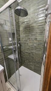 a shower with a glass door and a sink at Baltic Swans - Studio in Sopot