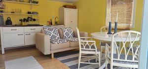 a kitchen with a couch and a table and chairs at Ocean Breeze next to the Beach in Beddinge Strand +2 photos