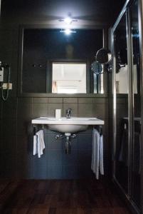 La salle de bains est pourvue d'un lavabo et d'un miroir. dans l'établissement L'Approdo delle Sirene, à Syracuse
