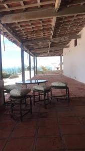 a picnic table and benches under a roof at Casa Pitombeira in Aracati