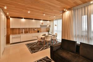 Seaview flat with pool & parking في مدينة فارنا: مطبخ وغرفة معيشة مع طاولة وكراسي