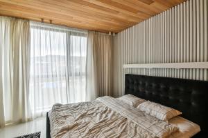 Seaview flat with pool & parking في مدينة فارنا: غرفة نوم بها سرير ونافذة كبيرة