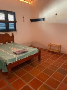 a bedroom with a bed in the corner of a room at Casa Pitombeira in Aracati