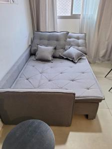 a couch with pillows on it in a living room at Espaço 26m Bela Vista in Sao Paulo