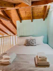 a bedroom with a large white bed with wooden ceilings at Live in Lemnos Studios in Moudhros +10 photos