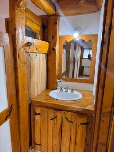 a bathroom with a sink and a mirror at Lodge Copahue Expeditions in Caviahue +60 photos