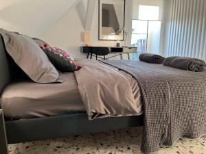 a bed with a blanket and pillows on it at Apartamenty CEKCYN - KOLEJOWA 6 in Cekcyn