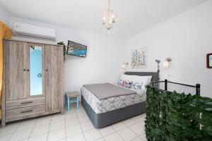 a bedroom with a bed and a wooden cabinet at Eloúnda blue city center WiFi traditional for two in Elounda