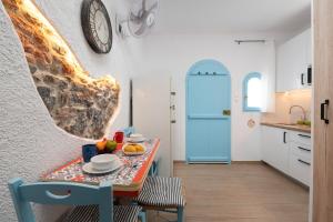a kitchen with a table and a clock on the wall at Eloúnda blue city center WiFi traditional for two in Elounda