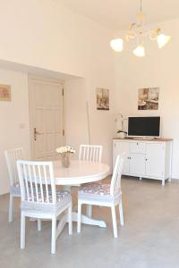 a dining room with a table and chairs and a tv at Villa Annarè in Martina Franca