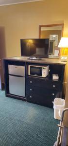 Habitación de hotel con TV y microondas. en Colonial Inn, en Dyersville