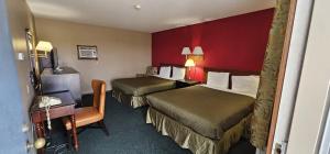 a hotel room with two beds and a chair at Colonial Inn in Dyersville