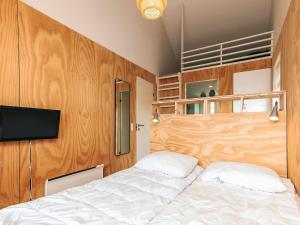 a bedroom with a bed and a flat screen tv at 4 star holiday home in Brovst in Brovst