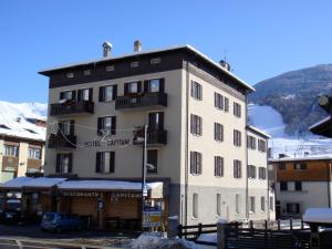 a large white building with a balcony on a mountain at Hotel Capitani in Bormio