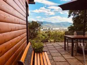 a wooden bench sitting on a patio with a table at Erdei Kabin Nagymaros in Nagymaros +11 photos