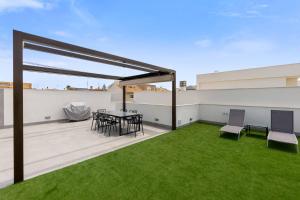 eine Terrasse mit einem Tisch und Stühlen auf dem Dach in der Unterkunft Sunny luxury corner house with private pool in San Pedro del Pinatar