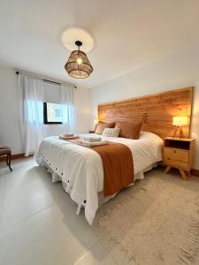 a bedroom with a large bed with a wooden headboard at Los Basaltos departamentos in Caviahue
