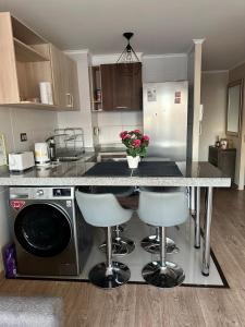 a kitchen with a counter with stools and a refrigerator at Departamento 2 habitaciones Temuco centro in Temuco