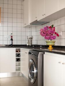 a kitchen with a vase of pink flowers on a washing machine at Blue Coast Villas - Villa 6 in Cidade Velha