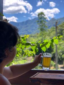 a young girl is holding a glass of beer at Casa das Palmeiras Pousada in Treviso