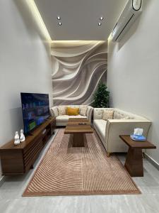 a living room with a couch and a tv at استديو فندقي فاخر بمدخل مستقل in Taif +3 photos