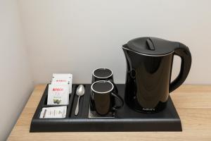a coffeemaker with a coffee maker on a counter at Divos Apartments in Vlorë