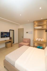 a bedroom with a large bed and a chair at Divos Apartments in Vlorë