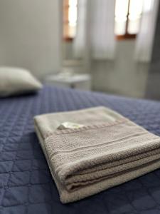 a pile of towels sitting on top of a bed at Hotel Brasil Real in Guaíba