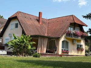 a house with a balcony with flowers on it at Apartment in Balatonbereny - Balaton 18046 in Balatonberény