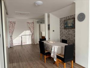 a dining room with a table and chairs and a clock at Apartment in Balatonbereny - Balaton 18047 in Balatonberény +16 photos