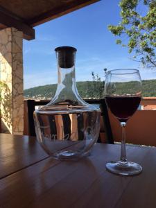 een glas wijn naast een wijnfles op een tafel bij Guesthouse Tariba in Supetarska Draga