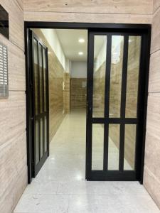 an open glass door in a building with a stone wall at city center hideaway in Durrës +1 photo