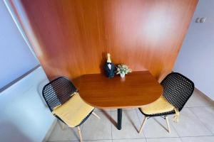 a wooden table with two chairs and a vase on it at Apartments by the sea nska, Krk - 24705 in Malinska