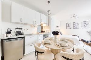 a white kitchen with a table and chairs at Studio Chic avec Cinéma Privé À 15 min de Disneyland et 20 min de Paris in Champs-Sur-Marne +24 photos