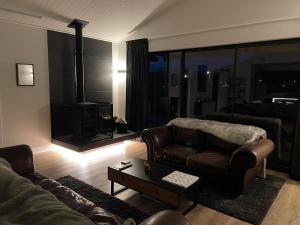 a living room with a couch and a table at Entire Hawea Holiday Home near Wanaka 2-10 guests in Lake Hawea