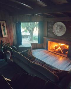 ein Wohnzimmer mit Kamin und Couch in der Unterkunft Haras Casa de Campo in San Martín de los Andes